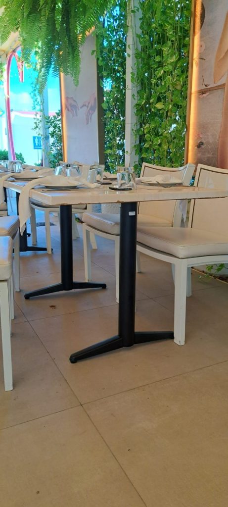 Mesa de comedor en restaurant Amore Mio Aruba con decoración elegante y verde