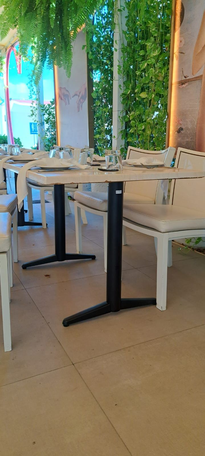 Mesa de comedor en restaurant Amore Mio Aruba con decoración elegante y verde