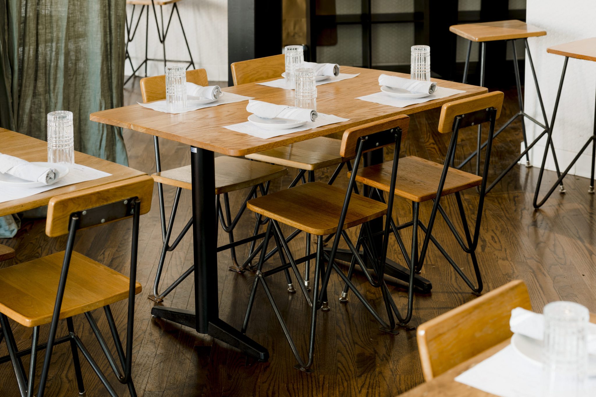 Restaurante Wooden Paddle, mesas de madera con servilletas y vasos
